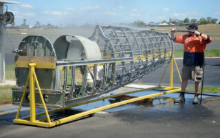 HFC volunteer Technical Team member cleaning the Spitfire fuselage upon arrival at Scone NSW from Toowoomba Qld